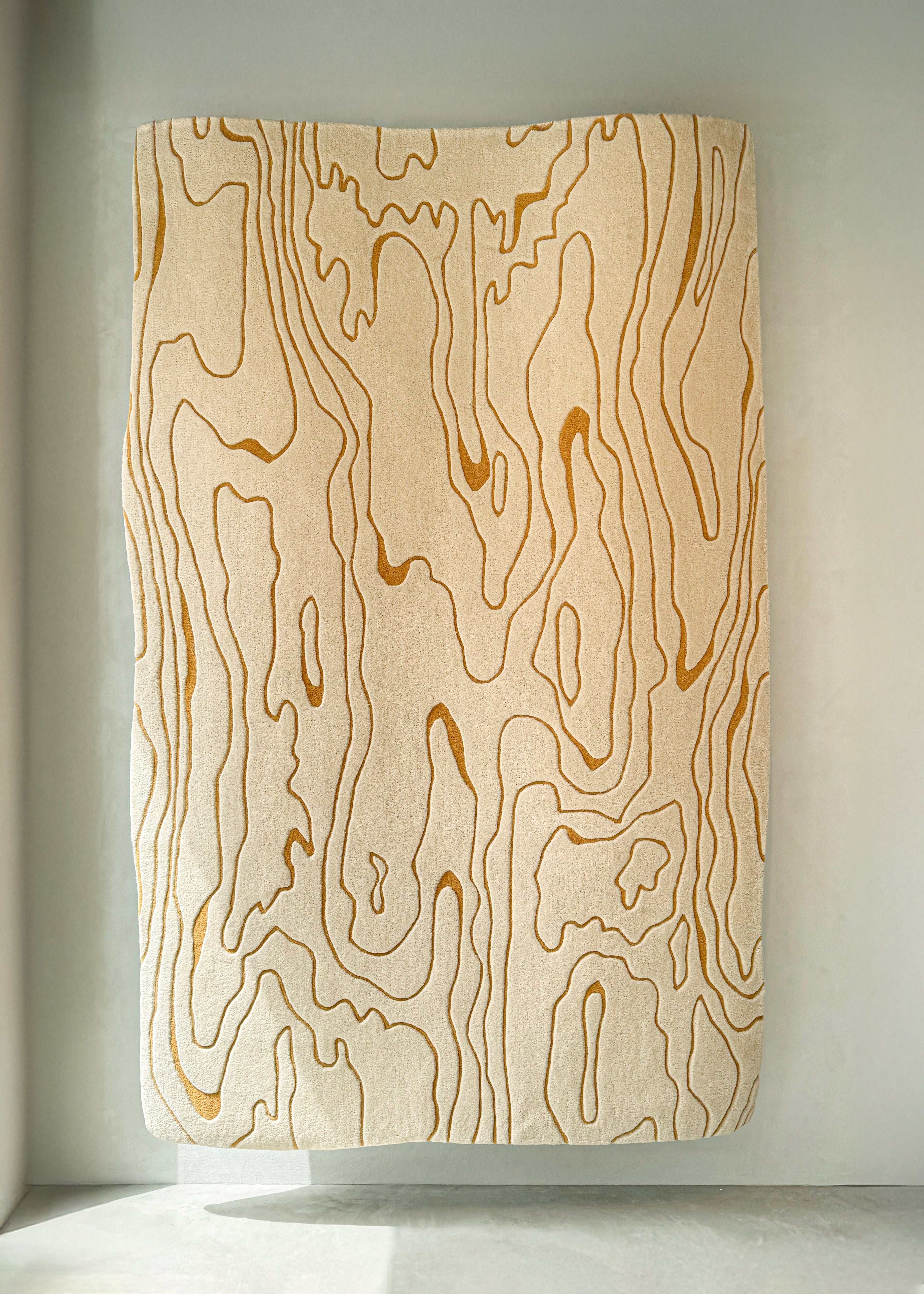 ETTORE wool rug with wood grain inspired layered pattern in warm beige tones – full view