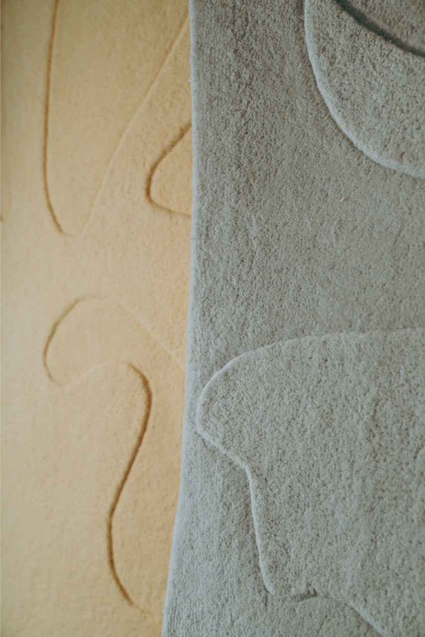 Close-up of textured beige and gray wall panels with abstract patterns.