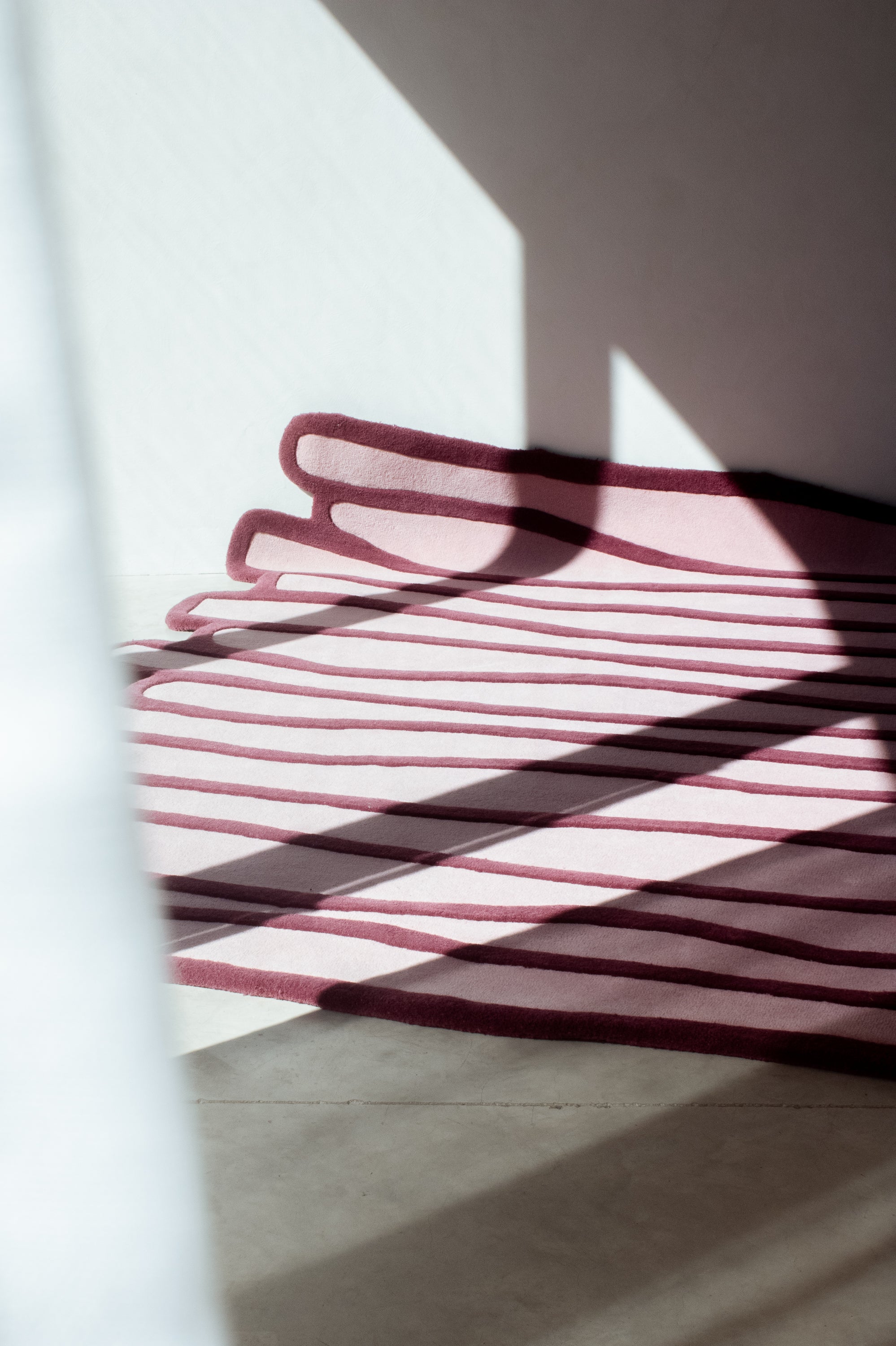 LAYERED wool rug with layered contour pattern and natural light shadows