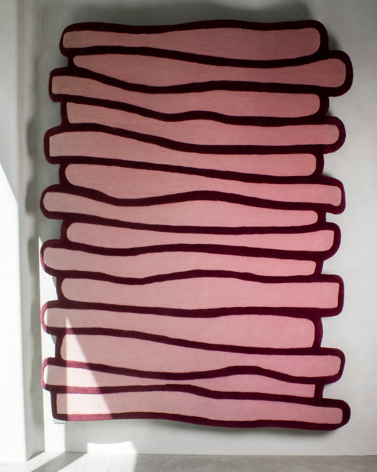 LAYERED wool rug with stacked organic pattern in soft pink and burgundy tones – full view