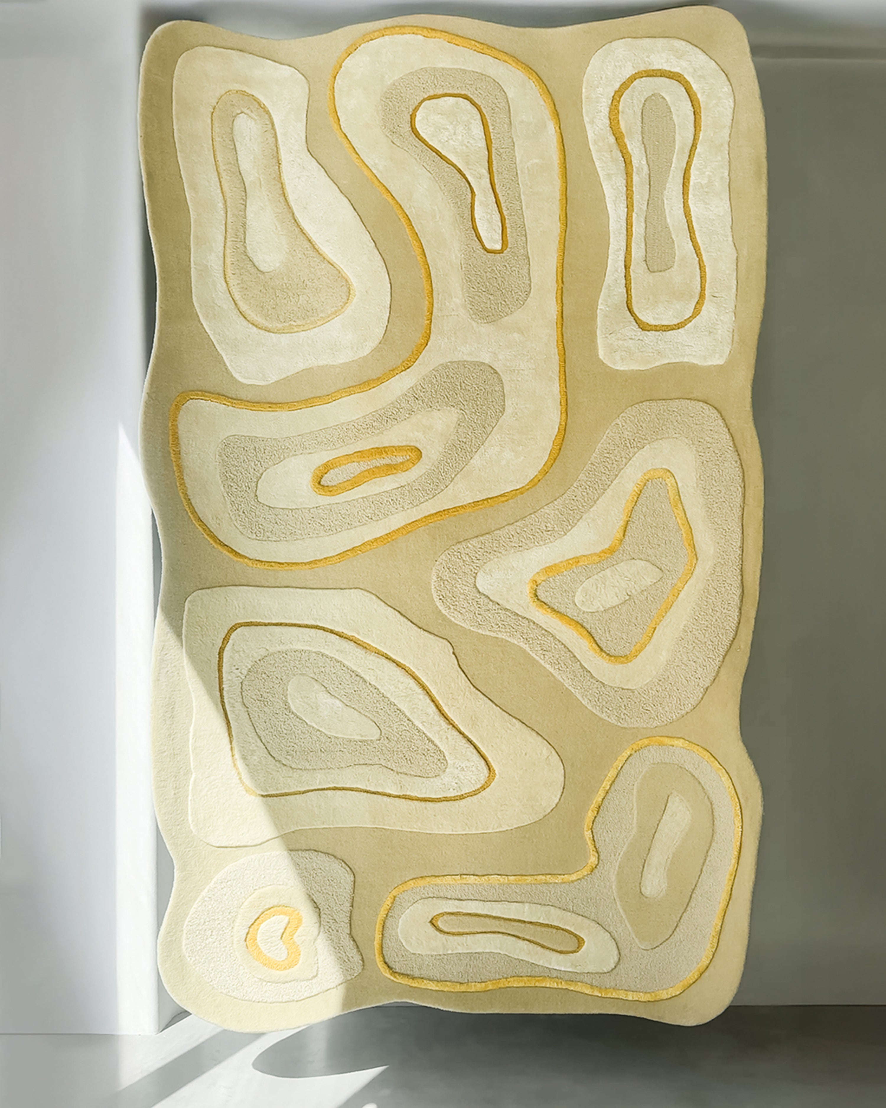 TEXTURED wool rug with layered organic pattern in cream and yellow tones – full view